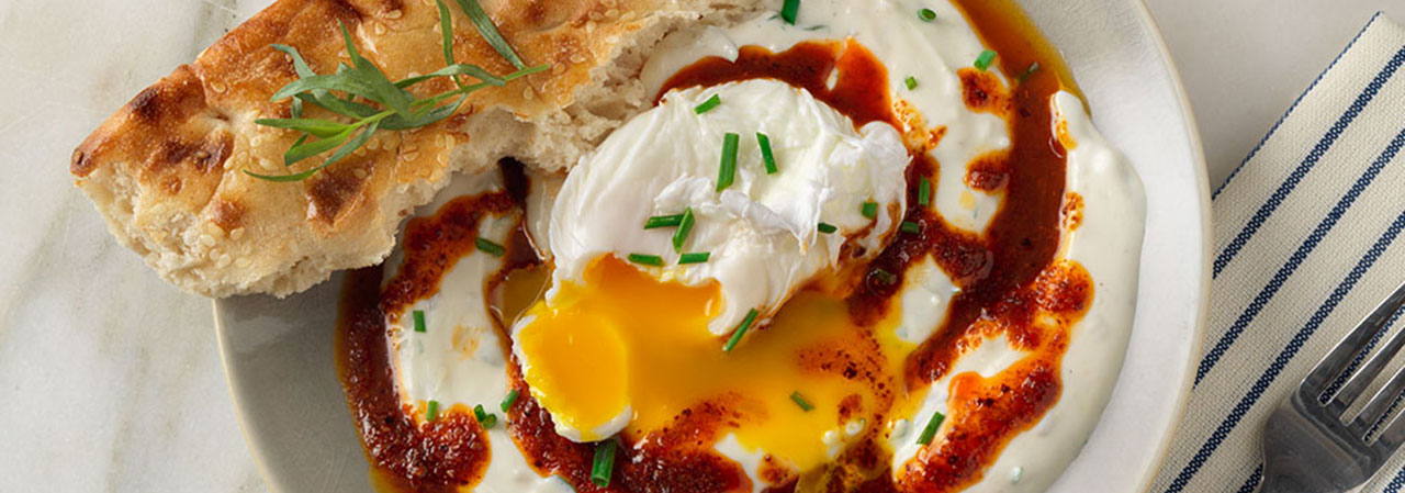 Poached Eggs on Spiced Yogurt with Aleppo Chili Drizzle and Barbari Bread